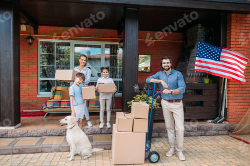 Preview: family with cardboard boxes and labrador dog standing on country house porch, moving home concept