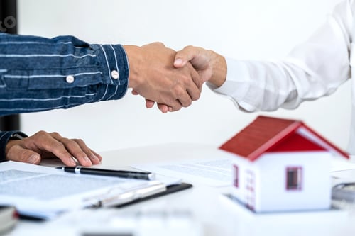 Preview: Real estate agent and customers shaking hands together celebrating finished contract after signing