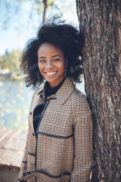 Preview: Beautiful African American woman in park. Spring or fall