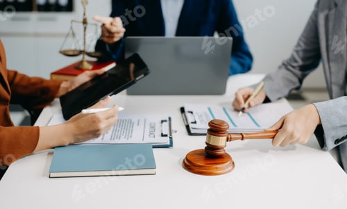 Preview: business people and lawyers discussing contract papers sitting at the table.