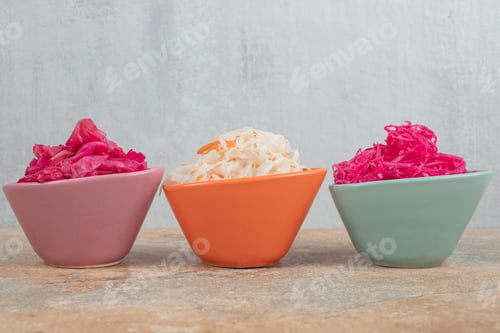 Preview: Three bowls of red and white sauerkraut on marble table