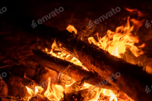 Preview: Logs burn brightly in a campfire, casting an inviting glow and warmth during a serene evening in the