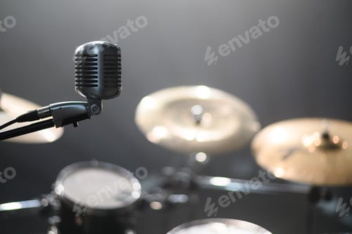 Preview: Close shot of a microphone standing on a stage with a drum kit in the background