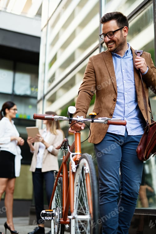 Preview: Portrait of happy fit business man with bicycle in modern city outdoors