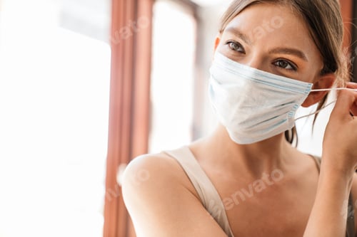 Preview: Close up of a young woman wearing medical mask