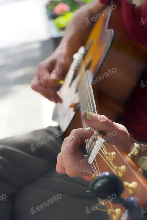 Preview: Unrecognizable elderly street guitarist musician busker plays acoustic guitar on a park bench