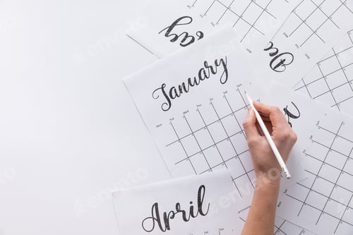 Preview: partial view of woman making notes in calendar isolated on white