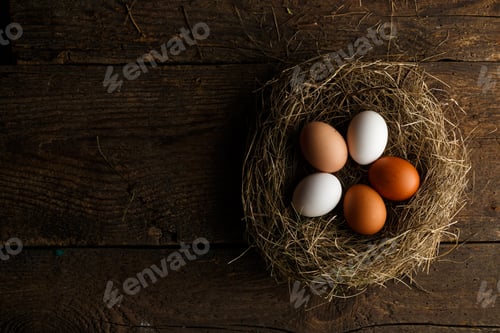 Preview: Fresh chicken eggs in a nest on a wooden background