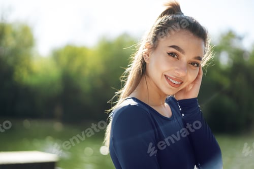 Preview: Portrait of a young smiling woman wearing sportswear in morning park