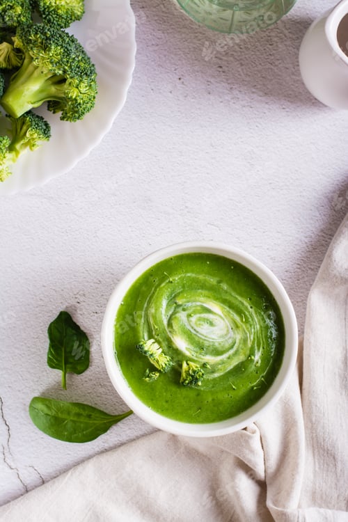 Preview: Bowl with broccoli cream soup on the table. Healthy food. Top and vertical view