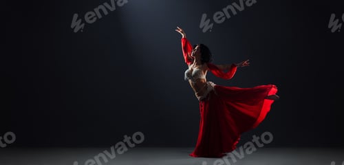Preview: Woman in red arabic dress dancing oriental dances arabesque pose