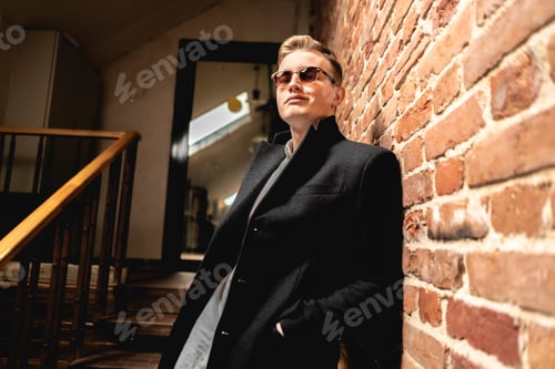 Preview: fashion look. stylish male in sunglasses stay in opposite of brick wall