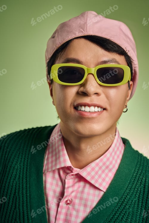 Preview: Fashion-forward asian man shows confidence in stylish pink checkered shirt and cardigan