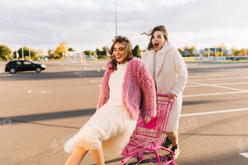 Preview: Stunning female friends posing at parking. Good-looking girls chilling in spring weekend