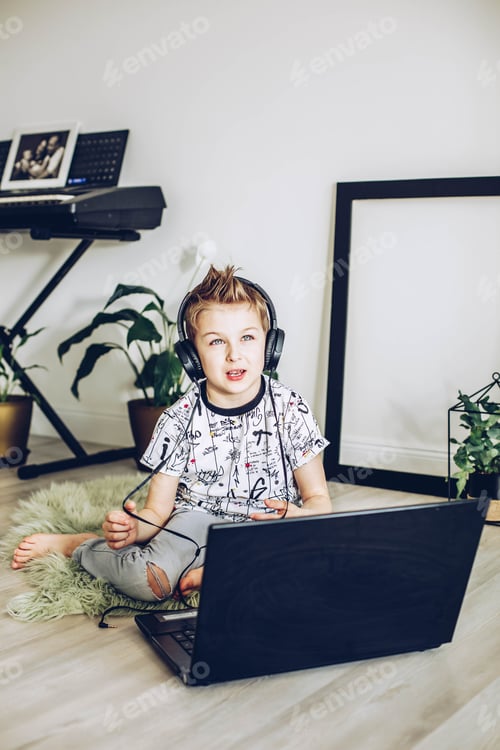 Preview: Boy Learning with Headphones and Laptop at Home
