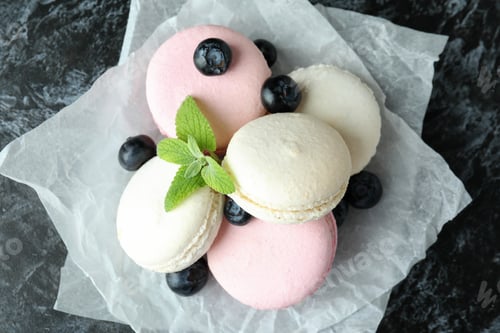 Preview: Concept of tasty dessert with macaroons on black smokey background