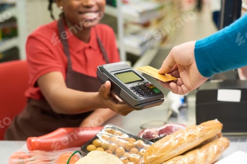 Preview: Buyer holding credit card over terminal payment while buying food products