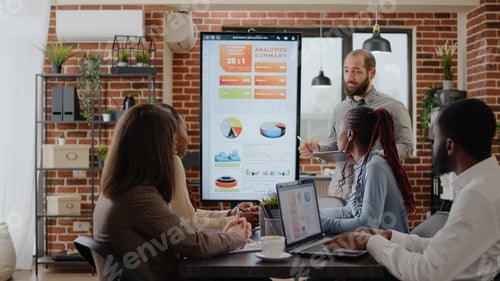Preview: Worker talking about business growth with charts on monitor