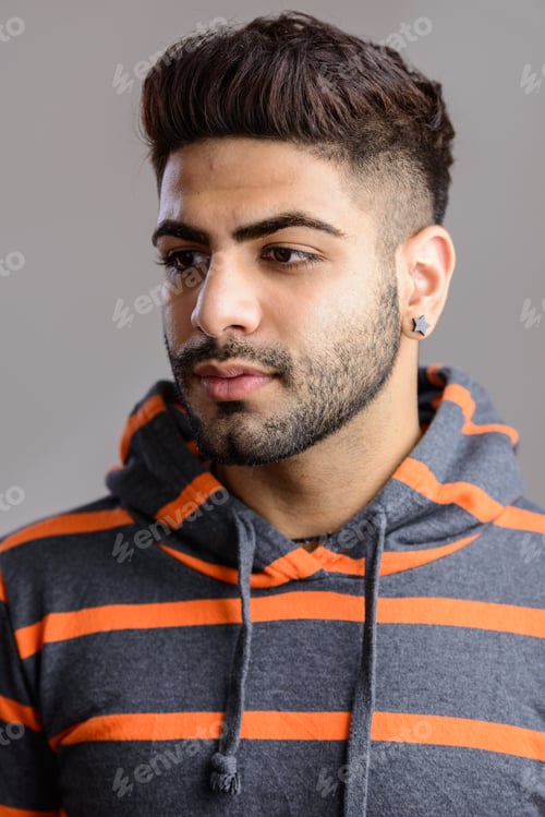Preview: Portrait shot of young handsome Indian man isolated against gray