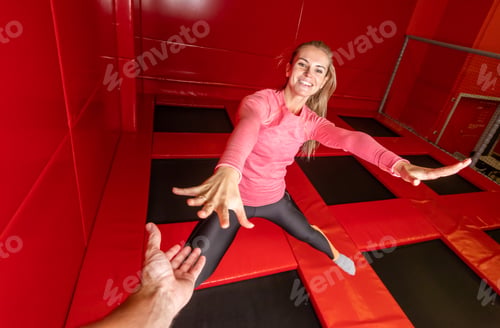 Preview: Fit young woman jumping on trampoline in fitness gym