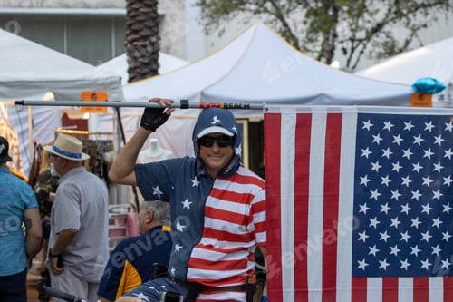 Preview: Man wearing a cap raises a flag in Coral Gables, Florida, USA