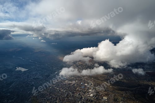 Preview: Aerial view from airplane window at high altitude of distant city