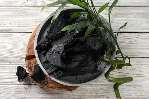 Preview: Tray with charcoal on white wooden table, top view