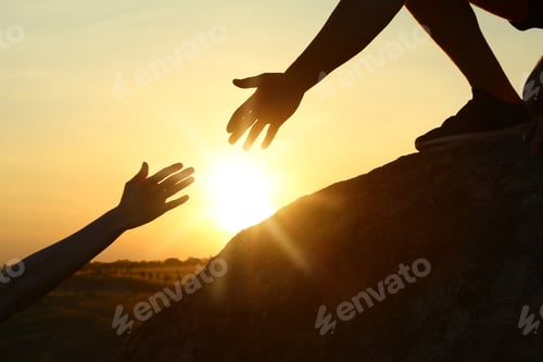 Preview: Hiker helping friend outdoors at sunset. Help and support concept