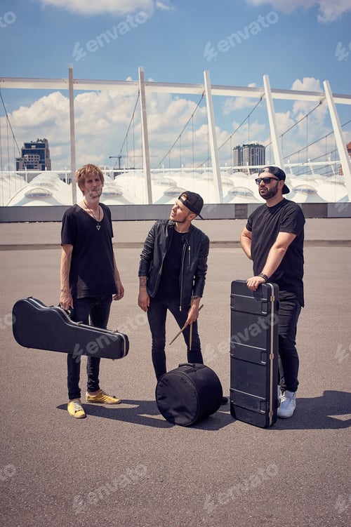 Preview: young musicians with musical instruments in cases standing on street