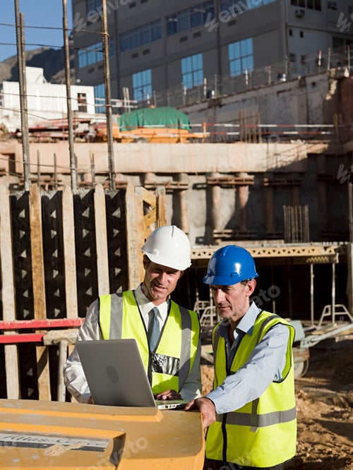 Preview: Two engineers reviewing plans on a construction site.