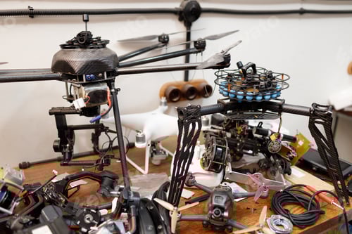 Preview: Workshop and repair production custom quadcopter UAV drones with parts on a table.