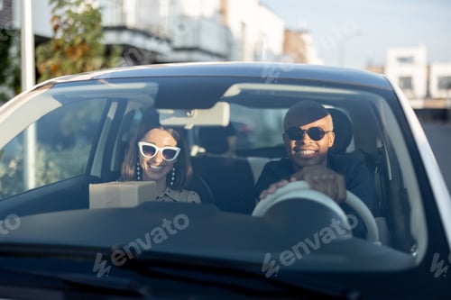 Preview: Multiracial couple riding in car at sunny day