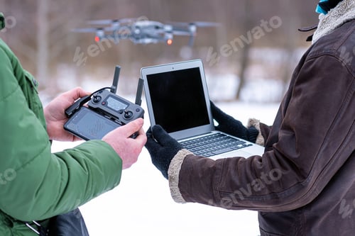 Preview: area planners survey the surroundings with a drone, hands with drone remote controller and a laptop