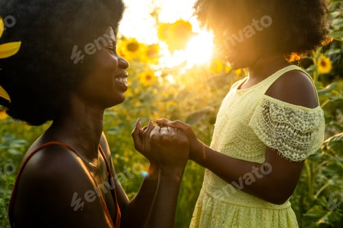 Preview: Beautiful mom and daughter in a sunflowers field