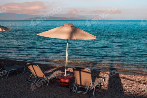Preview: Beach chairs and umbrella next to the sea