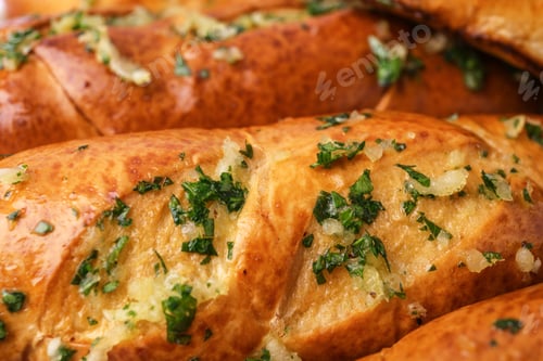Preview: Bread loaves with garlic and herbs as background, closeup