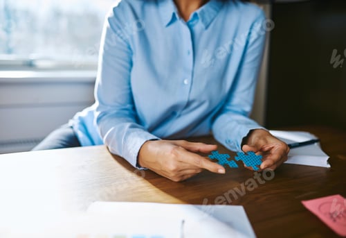 Preview: Close up of person assembling puzzle pieces