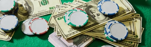 Preview: High angle view of dollar banknotes and casino chips on green background, panoramic shot
