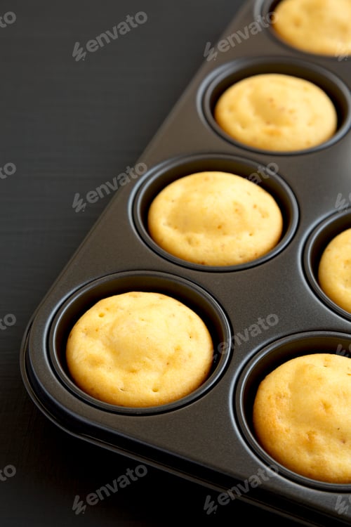 Preview: Homemade Cornbread Muffins on a black surface, low angle view. Copy space.