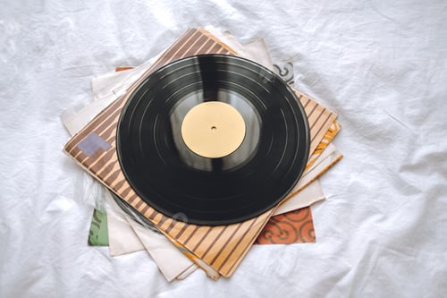 Preview: Old vinyl records on a white bed.