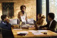 Preview: Confident business coach pointing at financial document