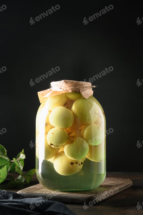 Preview: Homemade canned apple compote in large jar on dark board.