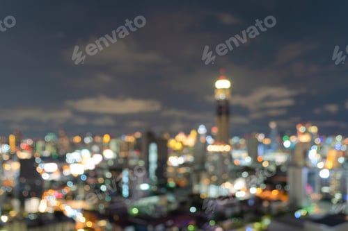 Preview: Bokeh of skyscraper buildings in city with lights, Blurry photo at night time. Cityscape background