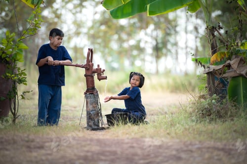 Preview: Childhood in rural Thailand. A small child assists his family by pumping natural water into a bucket