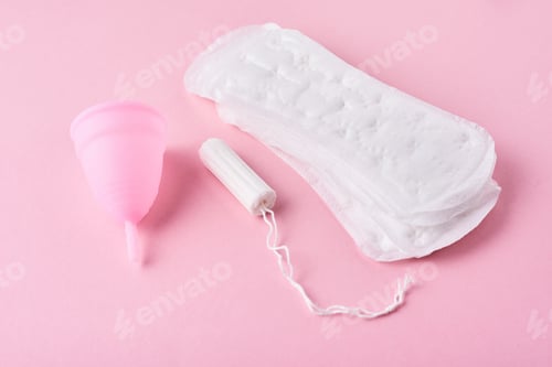 Preview: Sanitary pad, menstrual cup and tampon on a pink background