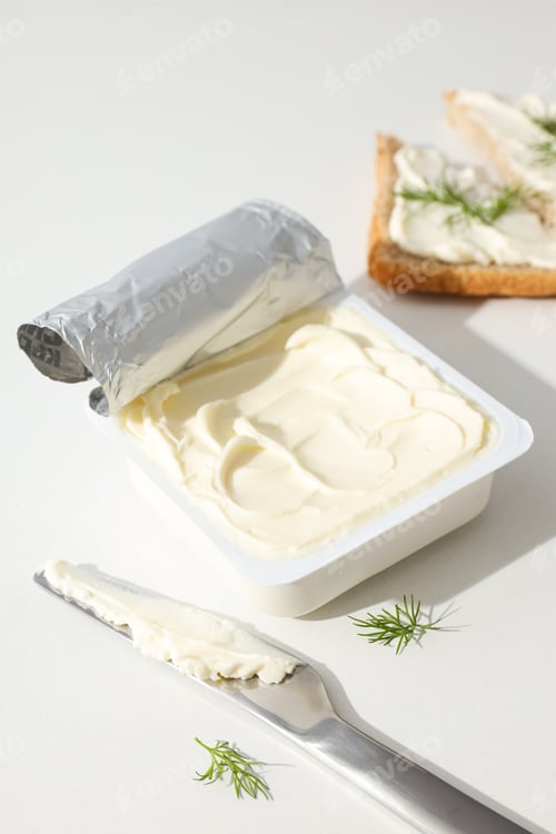 Preview: Philadelphia cheese in a plastic container, on a white background.