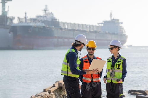 Preview: Workers discuss plans at a port with a cargo ship