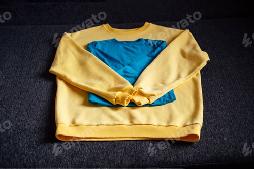 Preview: Humanitarian aid for Ukraine. Yellow, blue clothes in Ukrainian flag colors prepare to donation.