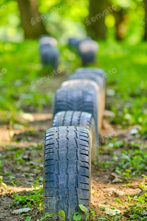 Preview: Vertical selective focus shot of car tires row in nature