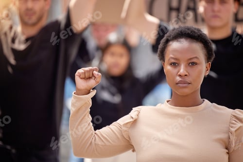 Preview: Dedicated to the cause. Shot of a young woman with her fist raised in solidarity at a march.